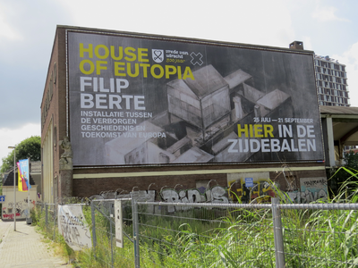907845 Afbeelding van de grote banner met o.a. de teksten 'HOUSE OF EUTOPIA' en 'HIER IN DE ZIJDEBALEN', op de zijgevel ...